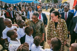 La Première ministre Judith Suminwa Tuluka et la ministre de l’Éducation nationale entourées d’élèves lors du lancement du programme des cantines scolaires à Kalemie.